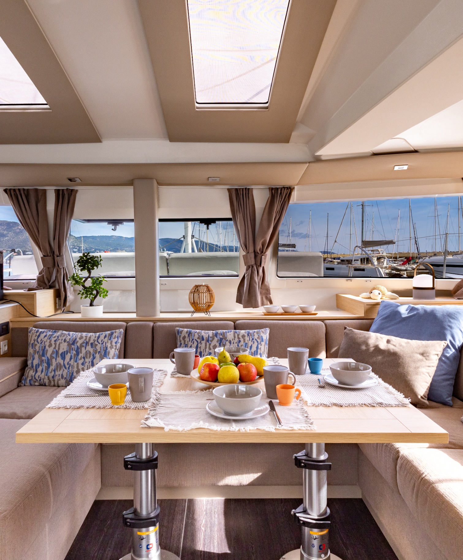 Bright saloon of HONU MOANA with dining table and panoramic windows
